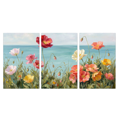 Colorful red, peach and yellow flowers beside a turquoise sea 3 piece canvas wall art viewed straight on