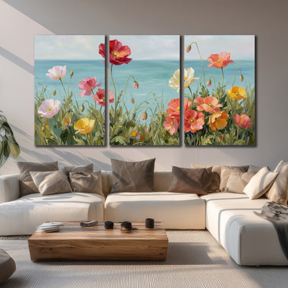 Colorful red, peach and yellow flowers beside a turquoise sea 3 piece canvas wall art displayed in a living room
