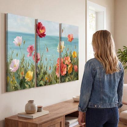 Colorful red, peach and yellow flowers beside a turquoise sea 3 piece canvas wall art three panel arrangement on a wall