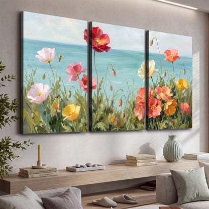 Colorful red, peach and yellow flowers beside a turquoise sea 3 piece canvas wall art displayed in a console