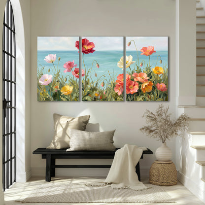 Colorful red, peach and yellow flowers beside a turquoise sea 3 piece canvas wall art displayed in a entryway