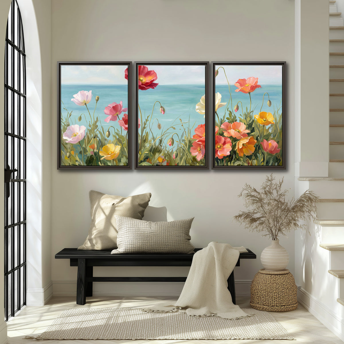 Colorful red, peach and yellow flowers beside a turquoise sea 3 piece framed canvas wall art displayed in a entryway