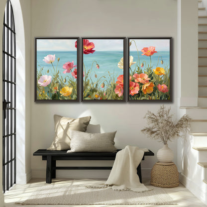 Colorful red, peach and yellow flowers beside a turquoise sea 3 piece framed canvas wall art displayed in a entryway