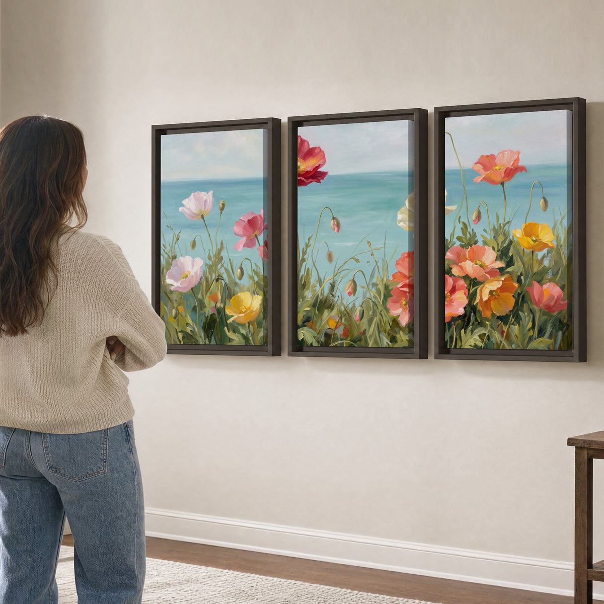 Colorful red, peach and yellow flowers beside a turquoise sea 3 piece framed canvas wall art three panel arrangement on a wall