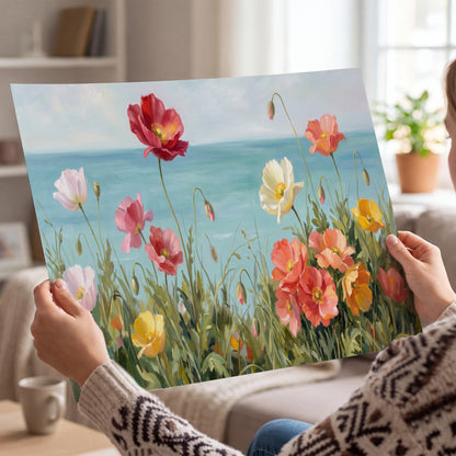 Colorful red, peach and yellow flowers beside a turquoise sea single poster print held in hands