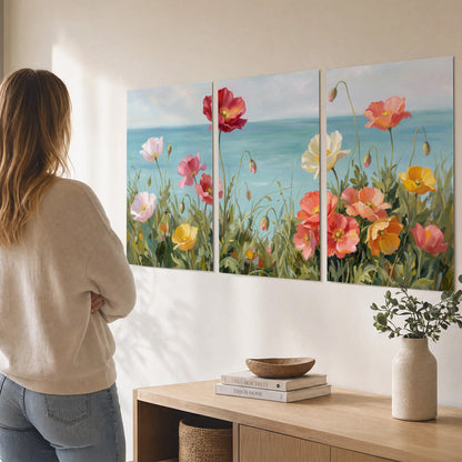 Colorful red, peach and yellow flowers beside a turquoise sea set of 3 poster prints three panel arrangement on a wall