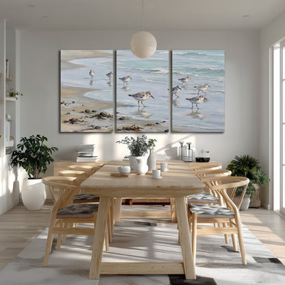 Small shorebirds standing along a pale blue shoreline 3 piece canvas wall art room and product view