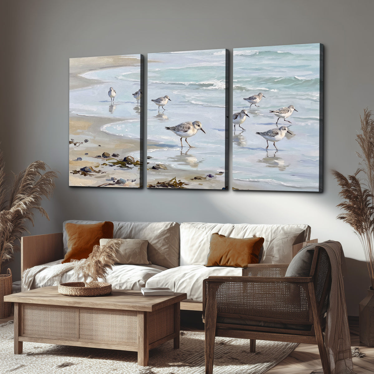 Small shorebirds standing along a pale blue shoreline 3 piece canvas wall art displayed in a rustic living room