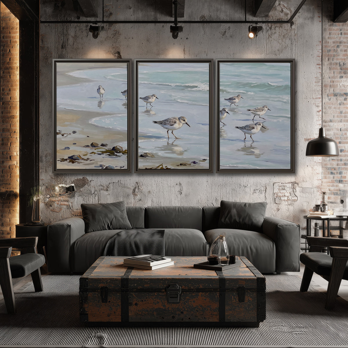 Small shorebirds standing along a pale blue shoreline 3 piece framed canvas wall art displayed in a industrial room