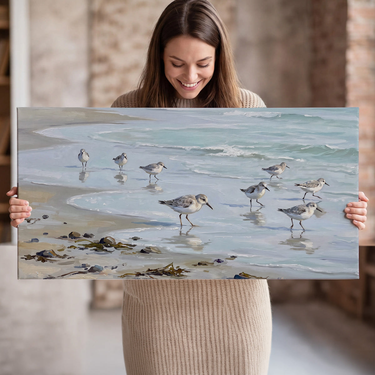 Small shorebirds standing along a pale blue shoreline single canvas wall art held in hands