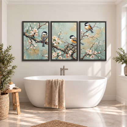 Small colorful songbirds perched among pale blossoms on soft aqua 3 piece framed canvas wall art styled in an interior