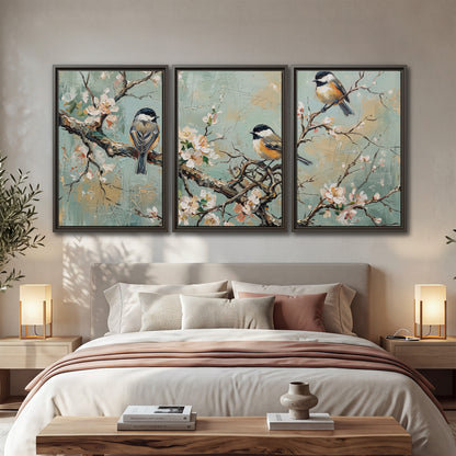 Small colorful songbirds perched among pale blossoms on soft aqua 3 piece framed canvas wall art displayed in a bedroom