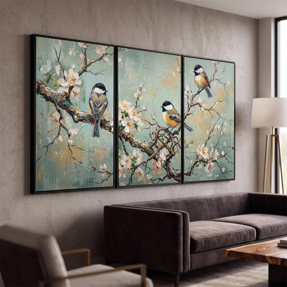 Small colorful songbirds perched among pale blossoms on soft aqua 3 piece framed canvas wall art displayed in a modern living room