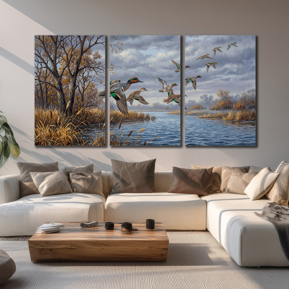 Ducks taking flight over a blue river framed by autumn branches 3 piece canvas wall art displayed in a living room