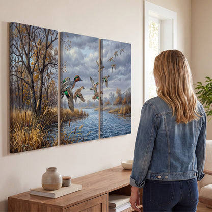 Ducks taking flight over a blue river framed by autumn branches 3 piece canvas wall art three panel arrangement on a wall