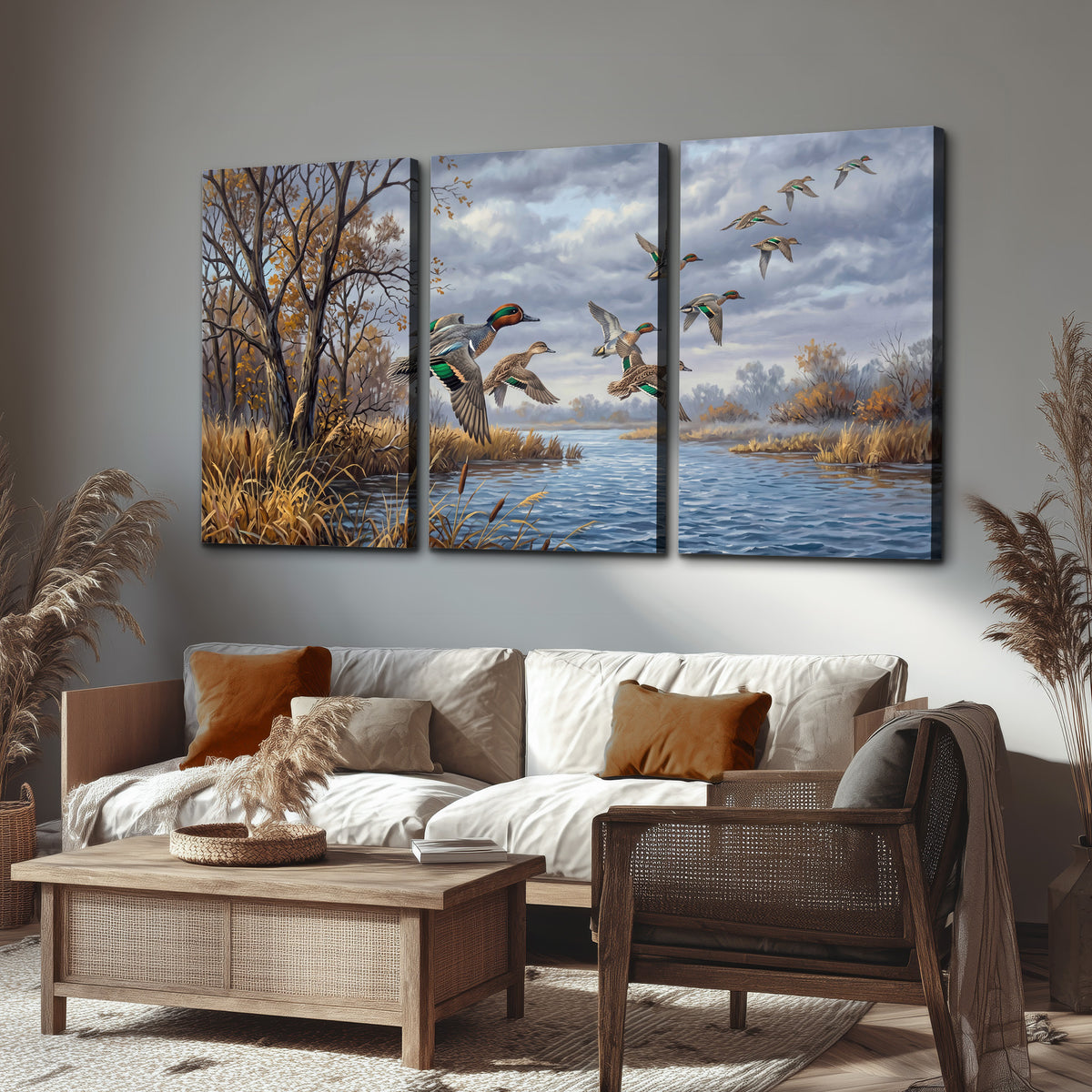 Ducks taking flight over a blue river framed by autumn branches 3 piece canvas wall art displayed in a rustic living room