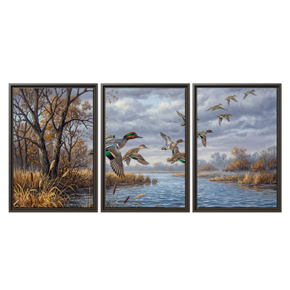 Ducks taking flight over a blue river framed by autumn branches 3 piece framed canvas wall art viewed straight on