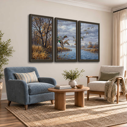 Ducks taking flight over a blue river framed by autumn branches 3 piece framed canvas wall art styled in an interior