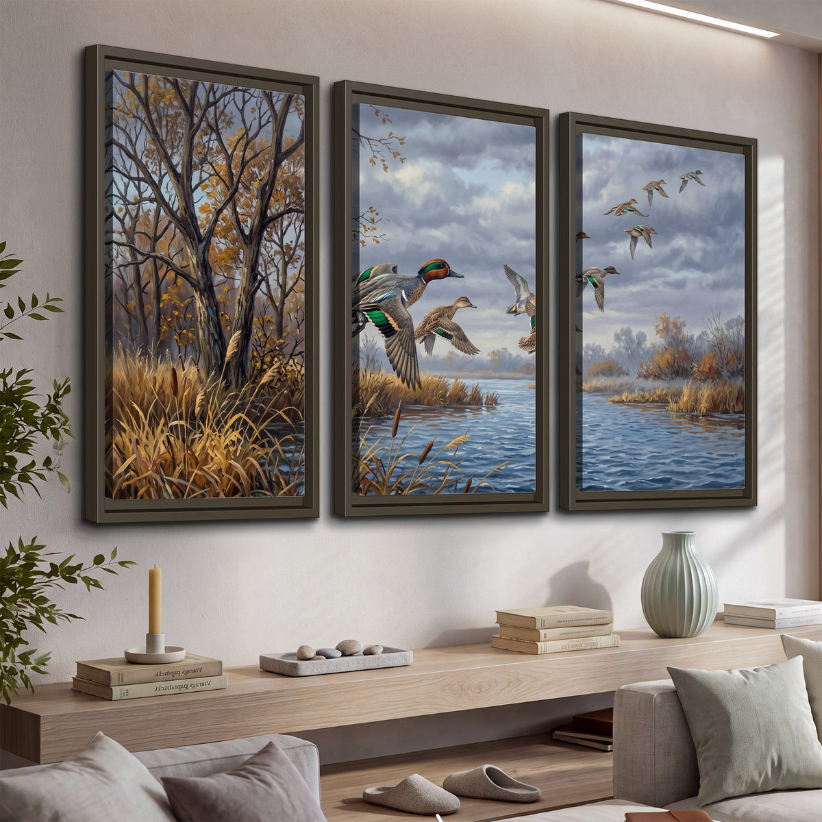 Ducks taking flight over a blue river framed by autumn branches 3 piece framed canvas wall art displayed in a console