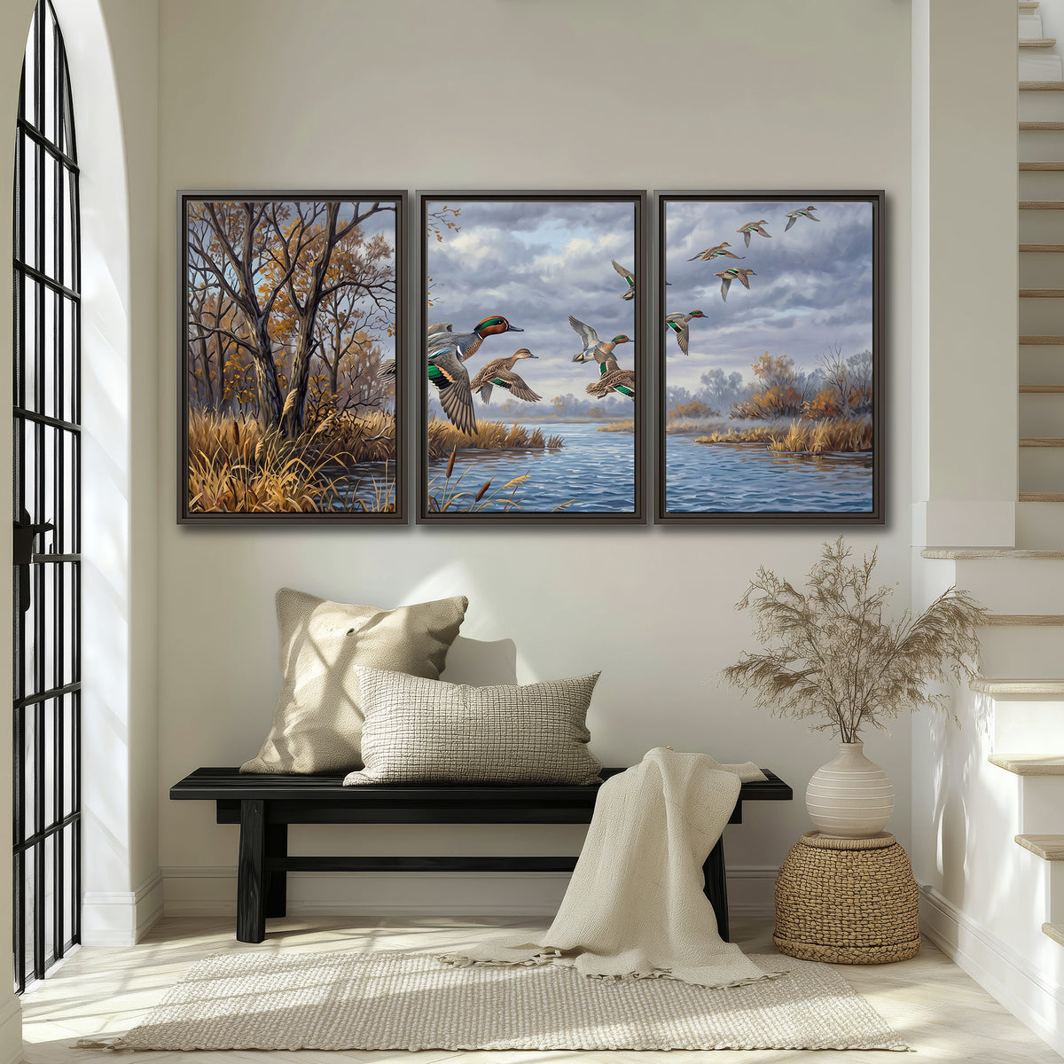 Ducks taking flight over a blue river framed by autumn branches 3 piece framed canvas wall art displayed in a entryway