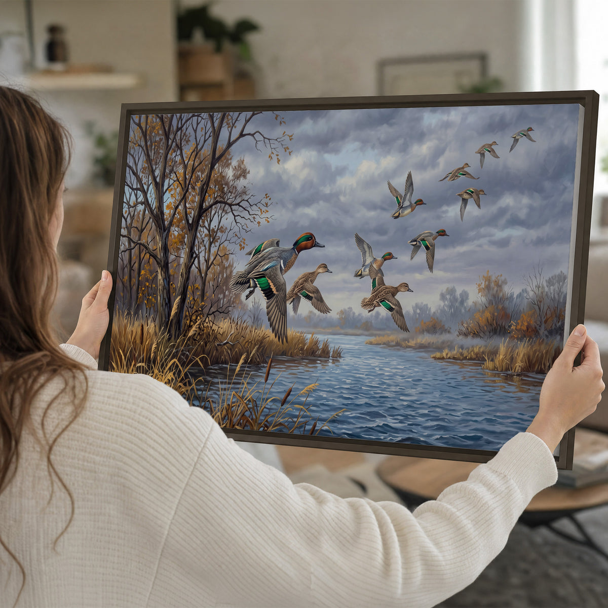 Ducks taking flight over a blue river framed by autumn branches single framed canvas wall art held in hands