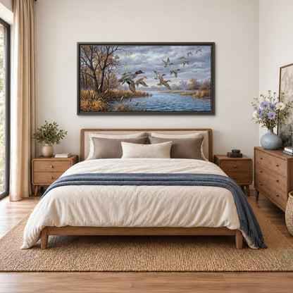 Ducks taking flight over a blue river framed by autumn branches single framed canvas wall art styled in an interior