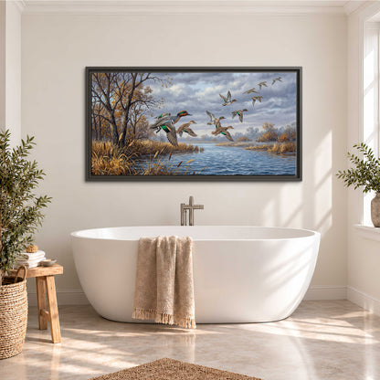 Ducks taking flight over a blue river framed by autumn branches single framed canvas wall art styled in an interior