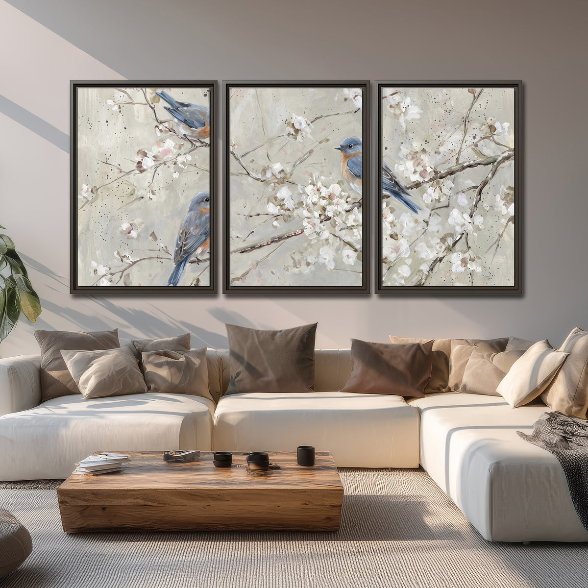 Bluebirds perched on delicate white flowering branches against pale sage 3 piece framed canvas wall art displayed in a living room