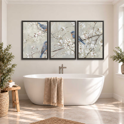 Bluebirds perched on delicate white flowering branches against pale sage 3 piece framed canvas wall art styled in an interior