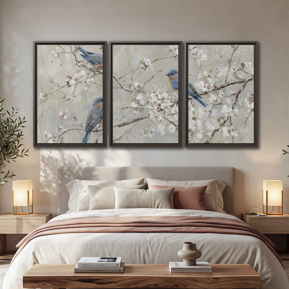 Bluebirds perched on delicate white flowering branches against pale sage 3 piece framed canvas wall art displayed in a bedroom