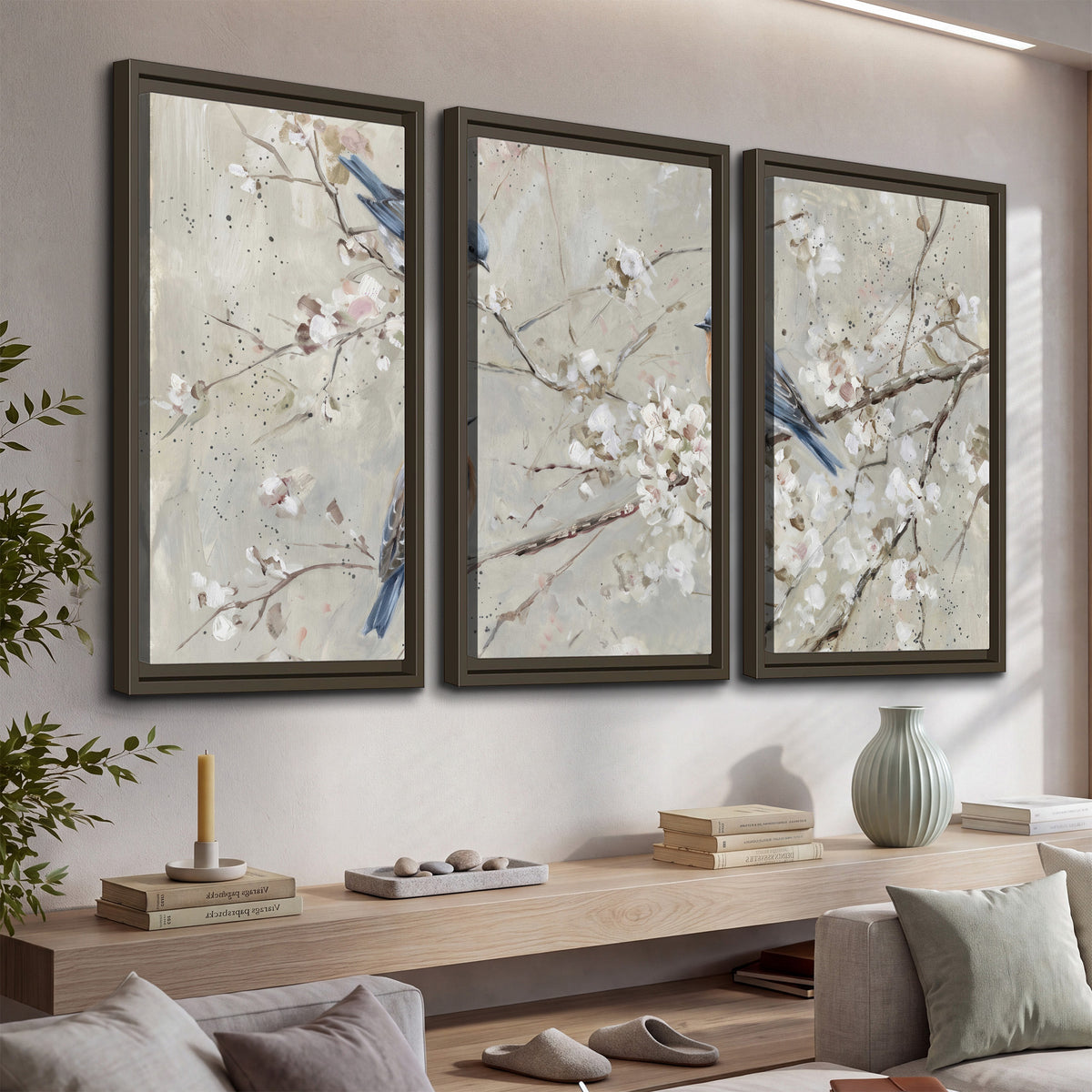 Bluebirds perched on delicate white flowering branches against pale sage 3 piece framed canvas wall art displayed in a console