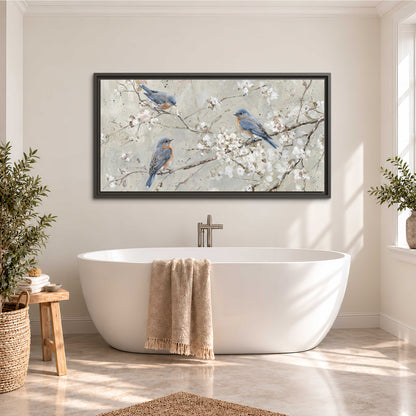 Bluebirds perched on delicate white flowering branches against pale sage single framed canvas wall art styled in an interior