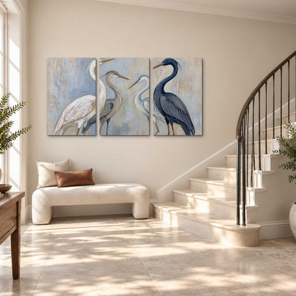 Three long-necked herons in soft ivory and dark blue against pale blue-gray 3 piece canvas wall art styled in an interior
