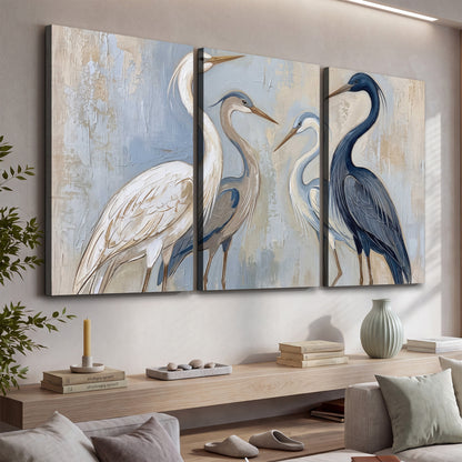 Three long-necked herons in soft ivory and dark blue against pale blue-gray 3 piece canvas wall art displayed in a console