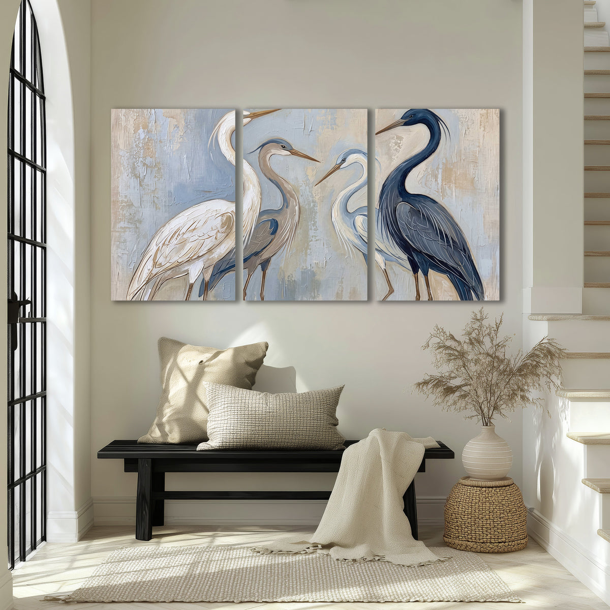 Three long-necked herons in soft ivory and dark blue against pale blue-gray 3 piece canvas wall art displayed in a entryway