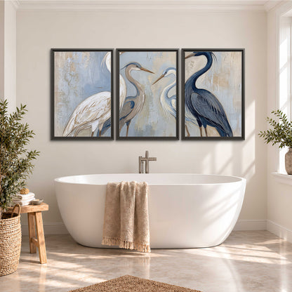 Three long-necked herons in soft ivory and dark blue against pale blue-gray 3 piece framed canvas wall art styled in an interior