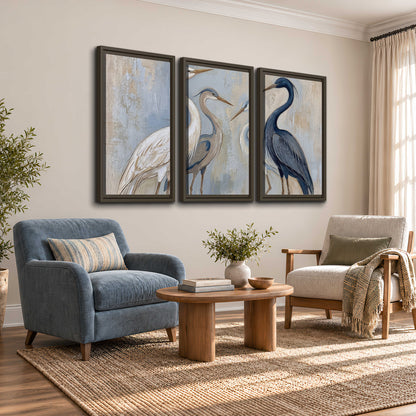 Three long-necked herons in soft ivory and dark blue against pale blue-gray 3 piece framed canvas wall art styled in an interior