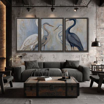 Three long-necked herons in soft ivory and dark blue against pale blue-gray 3 piece framed canvas wall art displayed in a industrial room
