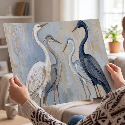 Three long-necked herons in soft ivory and dark blue against pale blue-gray single poster print held in hands