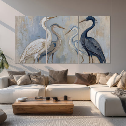 Three long-necked herons in soft ivory and dark blue against pale blue-gray set of 3 poster prints displayed in a living room