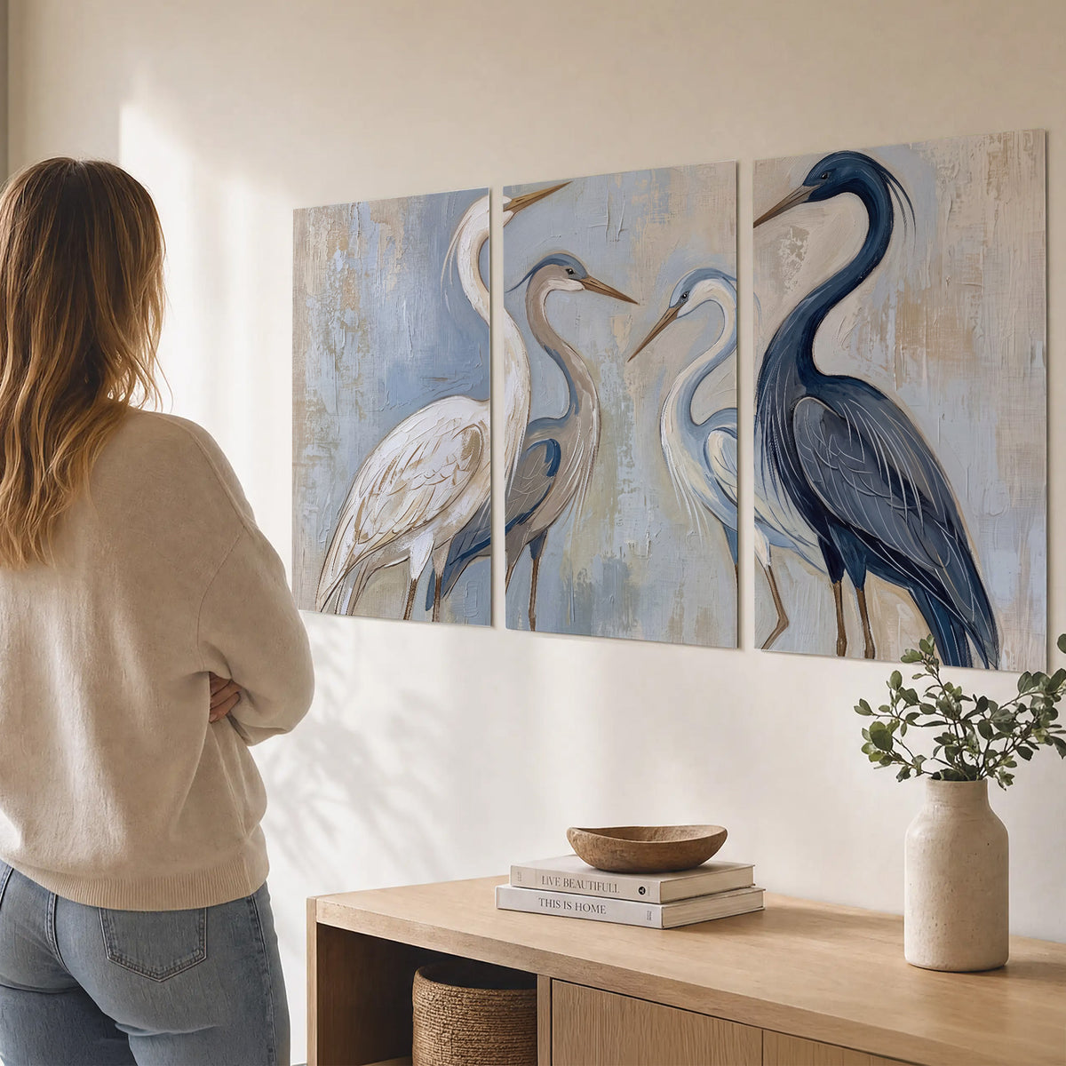 Three long-necked herons in soft ivory and dark blue against pale blue-gray set of 3 poster prints three panel arrangement on a wall