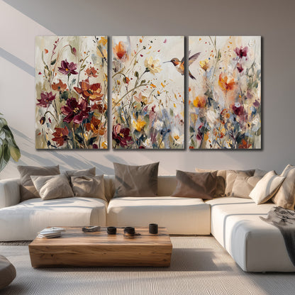 A small hummingbird among delicate pink, rust and ivory flowers 3 piece canvas wall art displayed in a living room