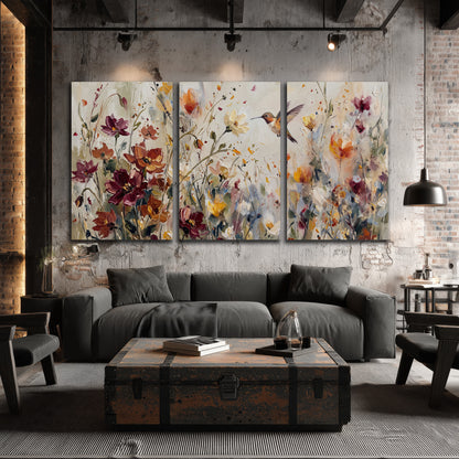 A small hummingbird among delicate pink, rust and ivory flowers 3 piece canvas wall art displayed in a industrial room