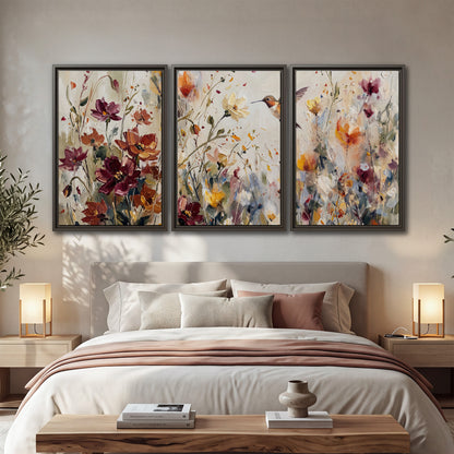 A small hummingbird among delicate pink, rust and ivory flowers 3 piece framed canvas wall art displayed in a bedroom