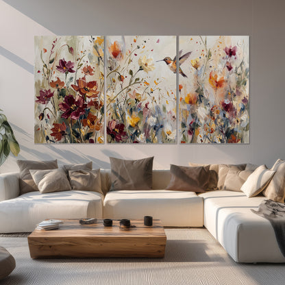 A small hummingbird among delicate pink, rust and ivory flowers set of 3 poster prints displayed in a living room