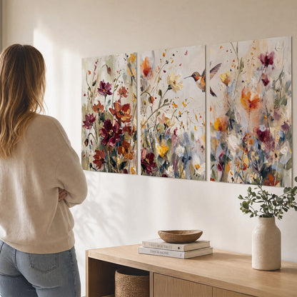 A small hummingbird among delicate pink, rust and ivory flowers set of 3 poster prints three panel arrangement on a wall