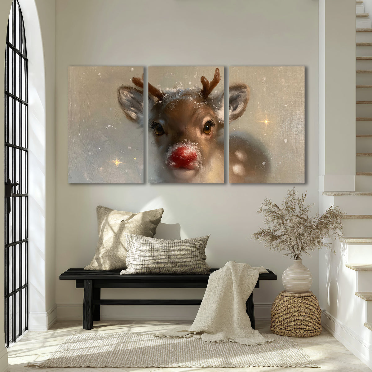 A young reindeer with a bright red nose surrounded by soft snowflakes and tiny painted stars 3 piece canvas wall art displayed in a entryway