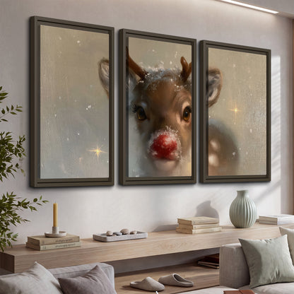 A young reindeer with a bright red nose surrounded by soft snowflakes and tiny painted stars 3 piece framed canvas wall art displayed in a console