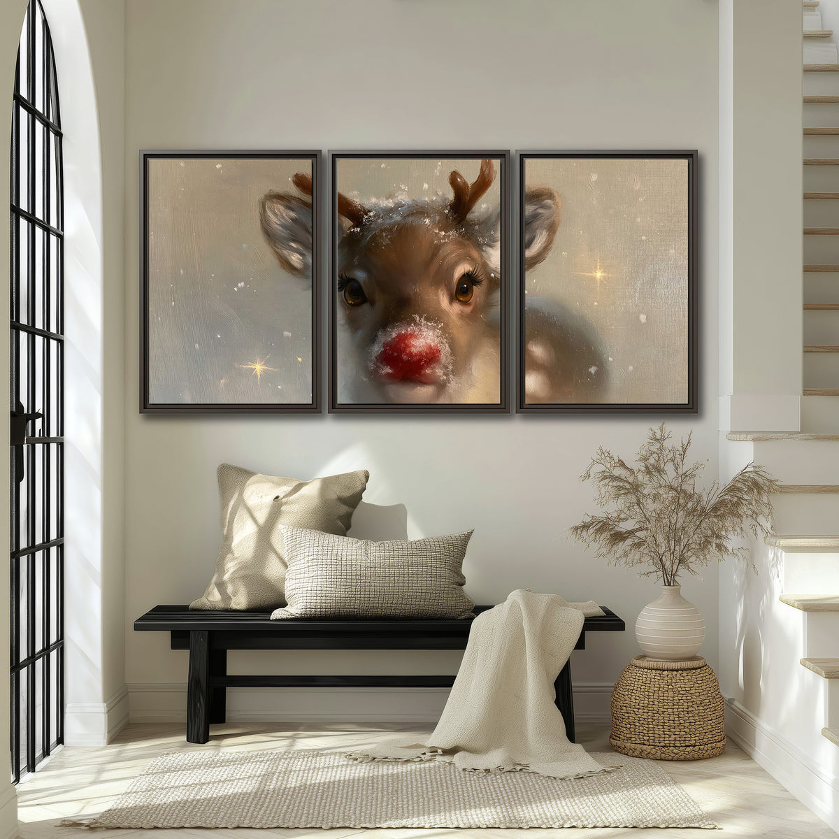A young reindeer with a bright red nose surrounded by soft snowflakes and tiny painted stars 3 piece framed canvas wall art displayed in a entryway