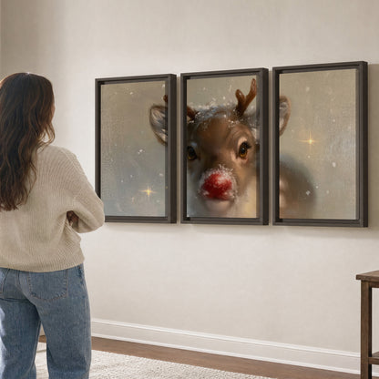 A young reindeer with a bright red nose surrounded by soft snowflakes and tiny painted stars 3 piece framed canvas wall art three panel arrangement on a wall